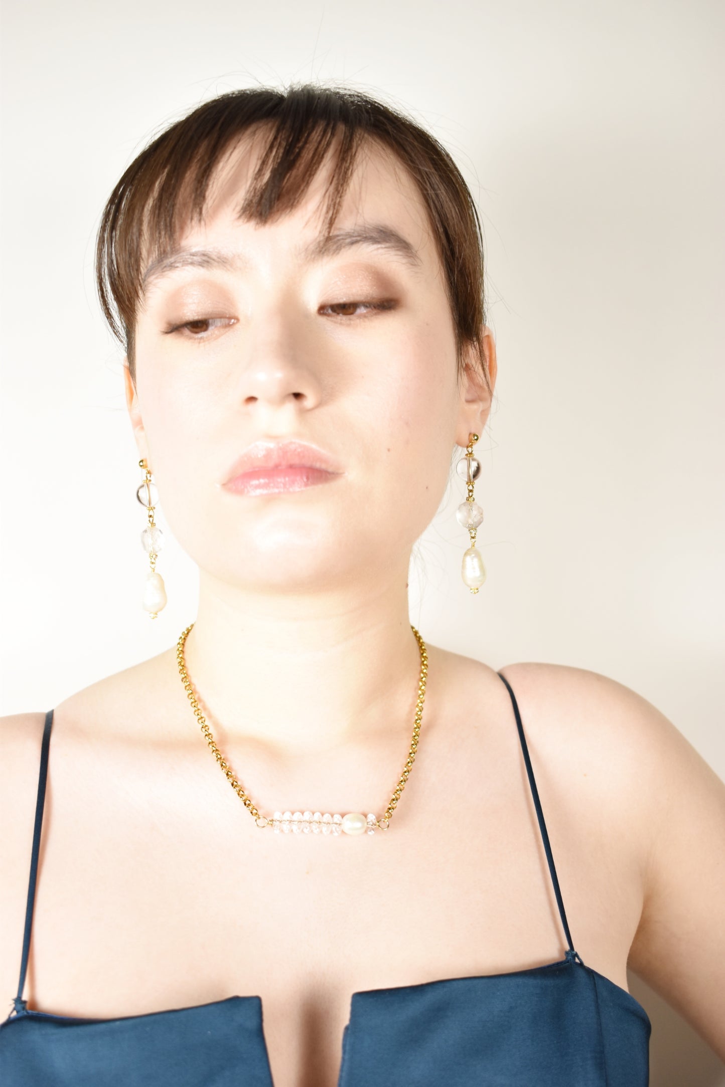 woman wearing beautiful drop crystal earrings and quartz necklace