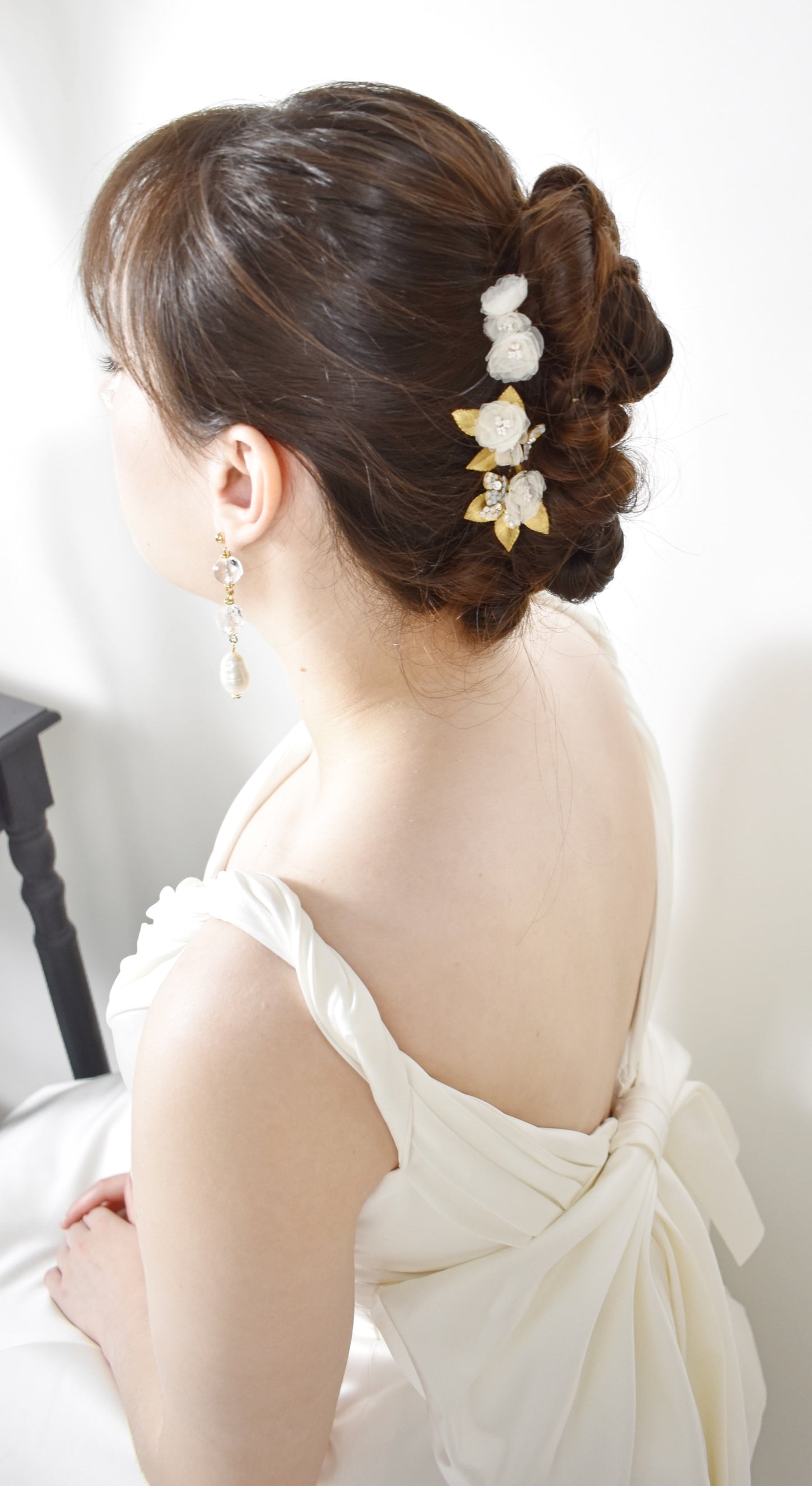 Woman with gilded age hair featuring hair adornments elements, wearing a wedding dress