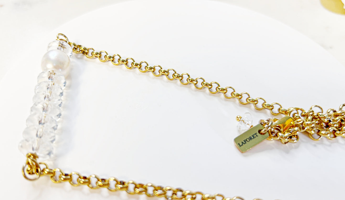 Gold chain necklace with pearls on a white background