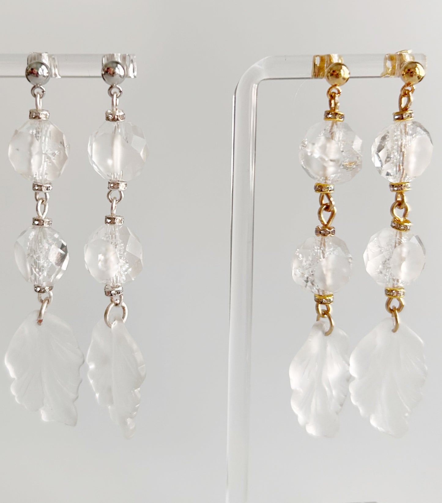 Pair of earrings with clear beads and gold accents on a white background