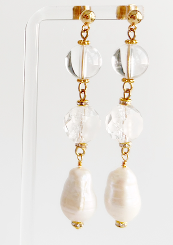 Pair of earrings with clear and gold elements on a white background