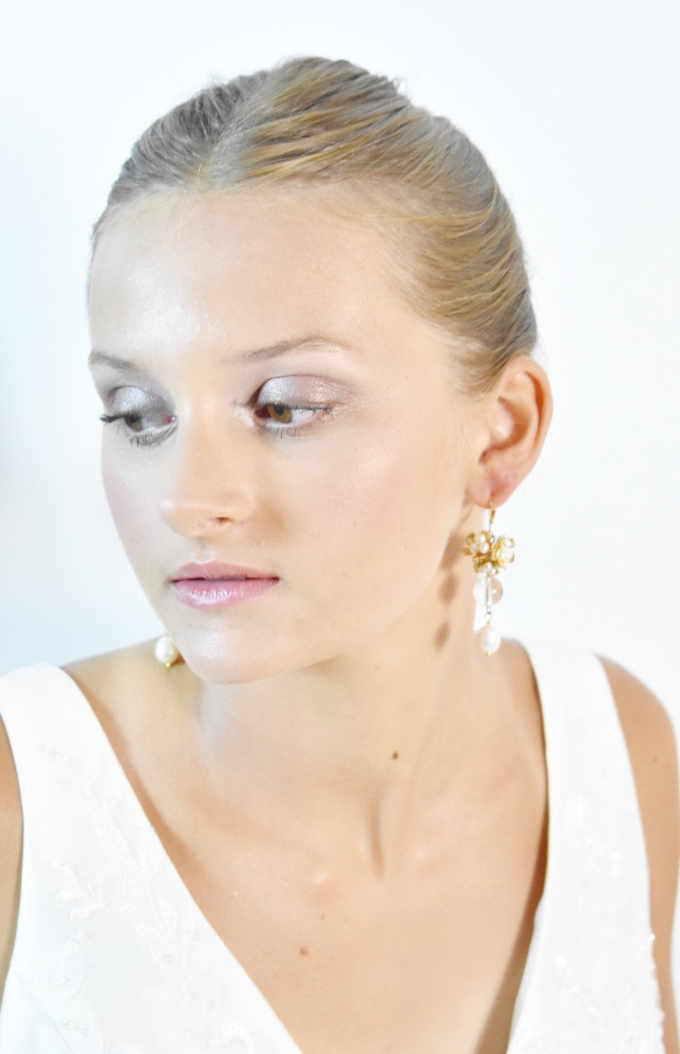 Woman wearing gold earrings against a white background