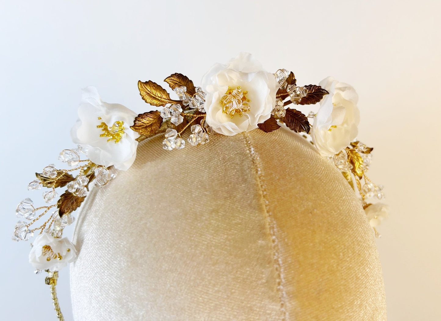 Decorative headband with flowers and gold accents on a white background