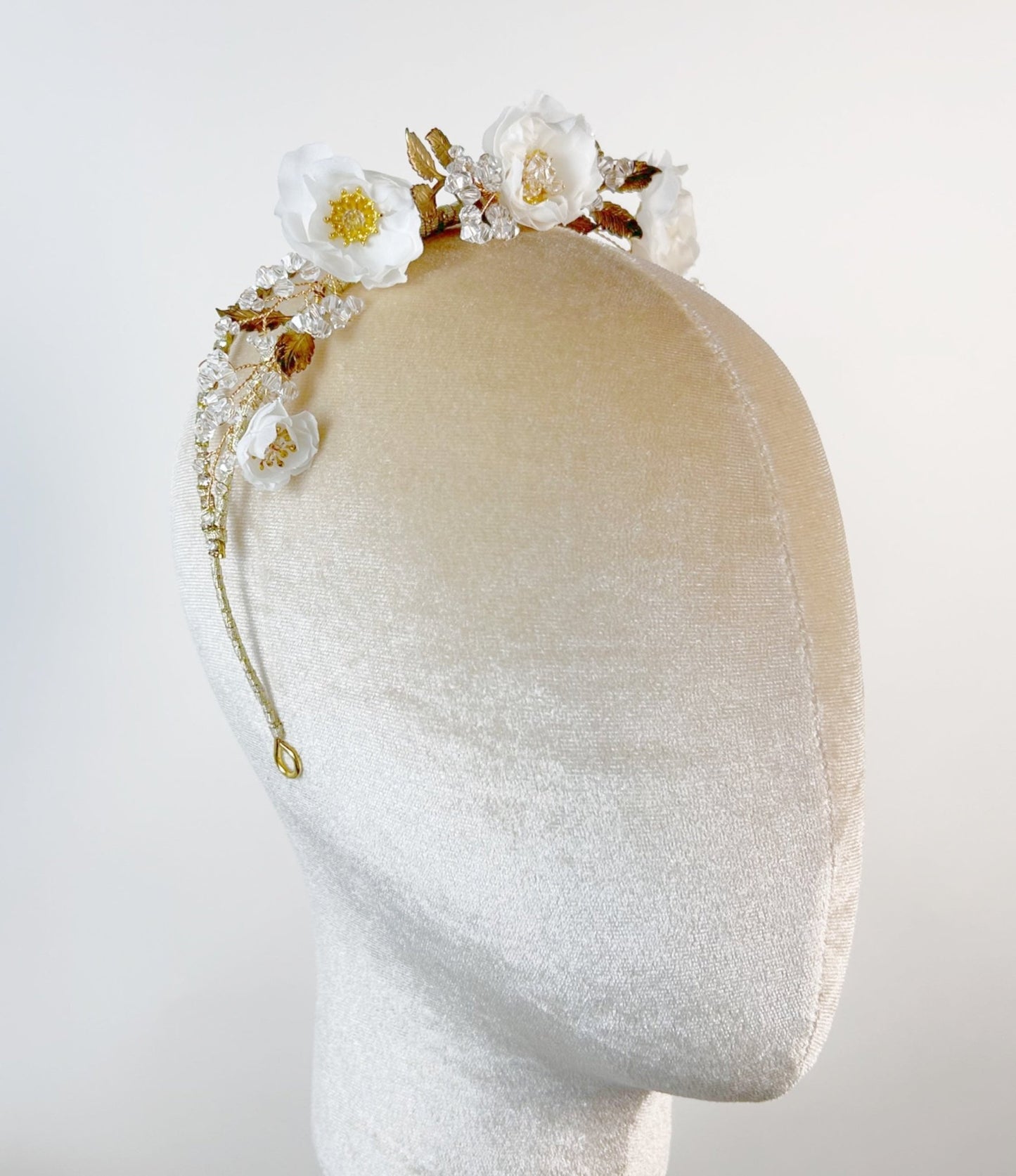 Floral headband on a mannequin head against a white background