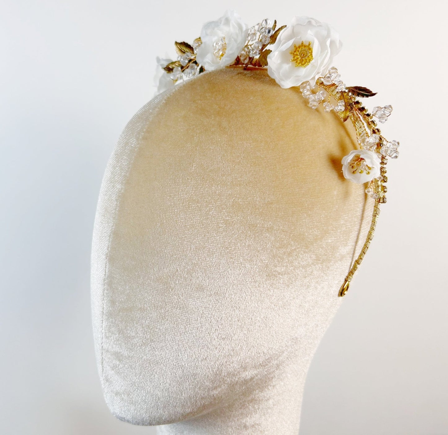 Decorative headband with flowers on a mannequin head against a white background