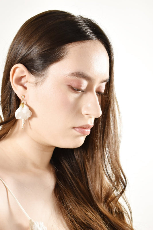 Woman wearing pearl earrings against a white background