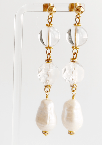 Pair of earrings with clear and gold elements on a white background