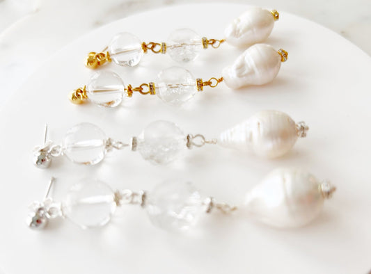 Set of pearl and crystal earrings on a white surface