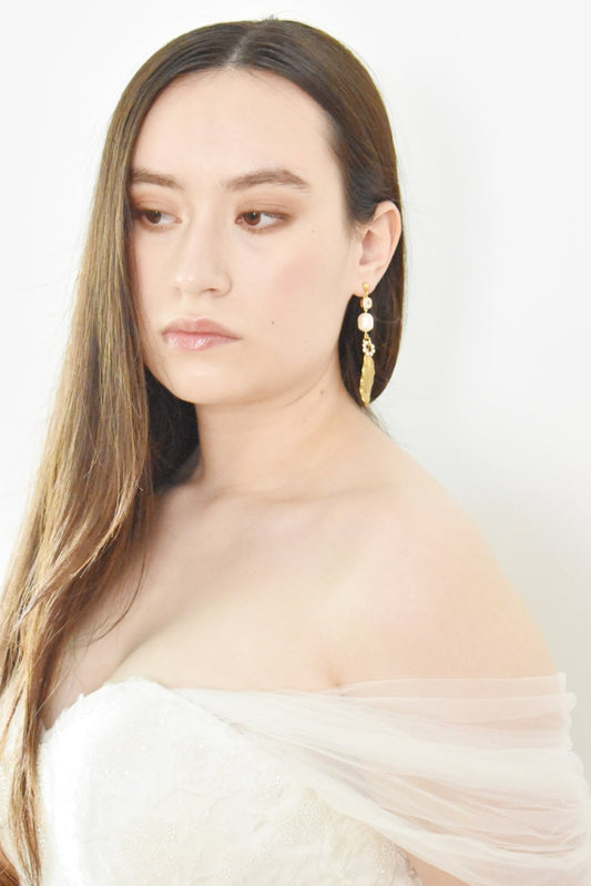 Woman wearing a white off-shoulder top with a plain background