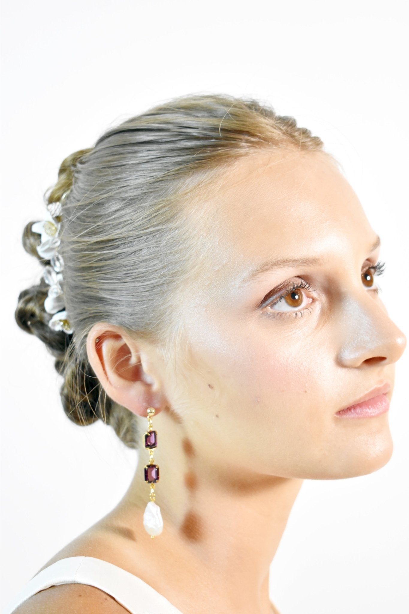Woman with styled hair and earrings on a white background