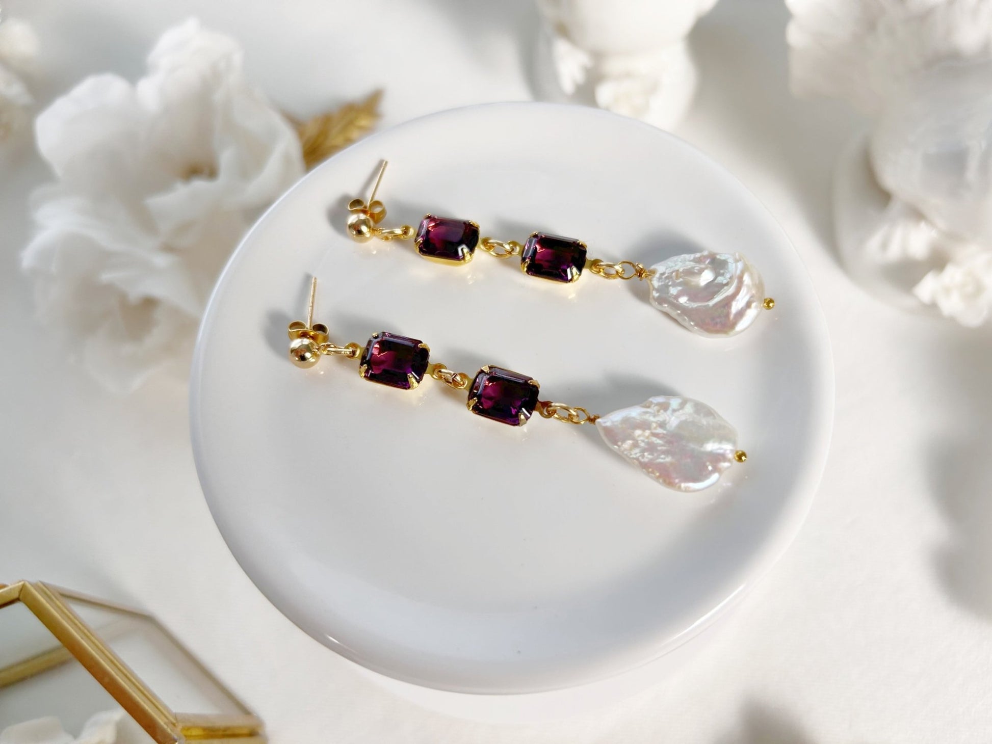 Pair of earrings with gemstones on a white surface