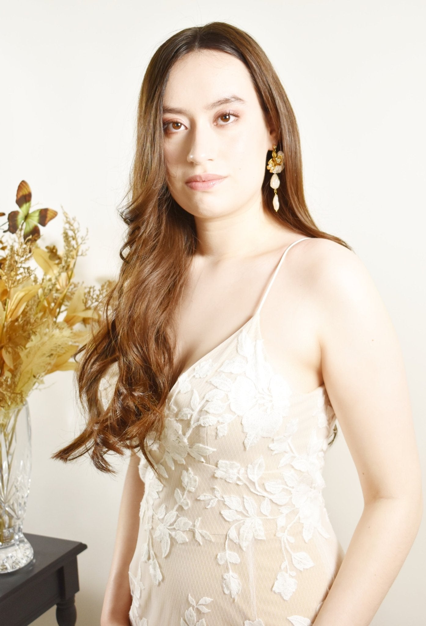 Woman in a white floral dress with a neutral background