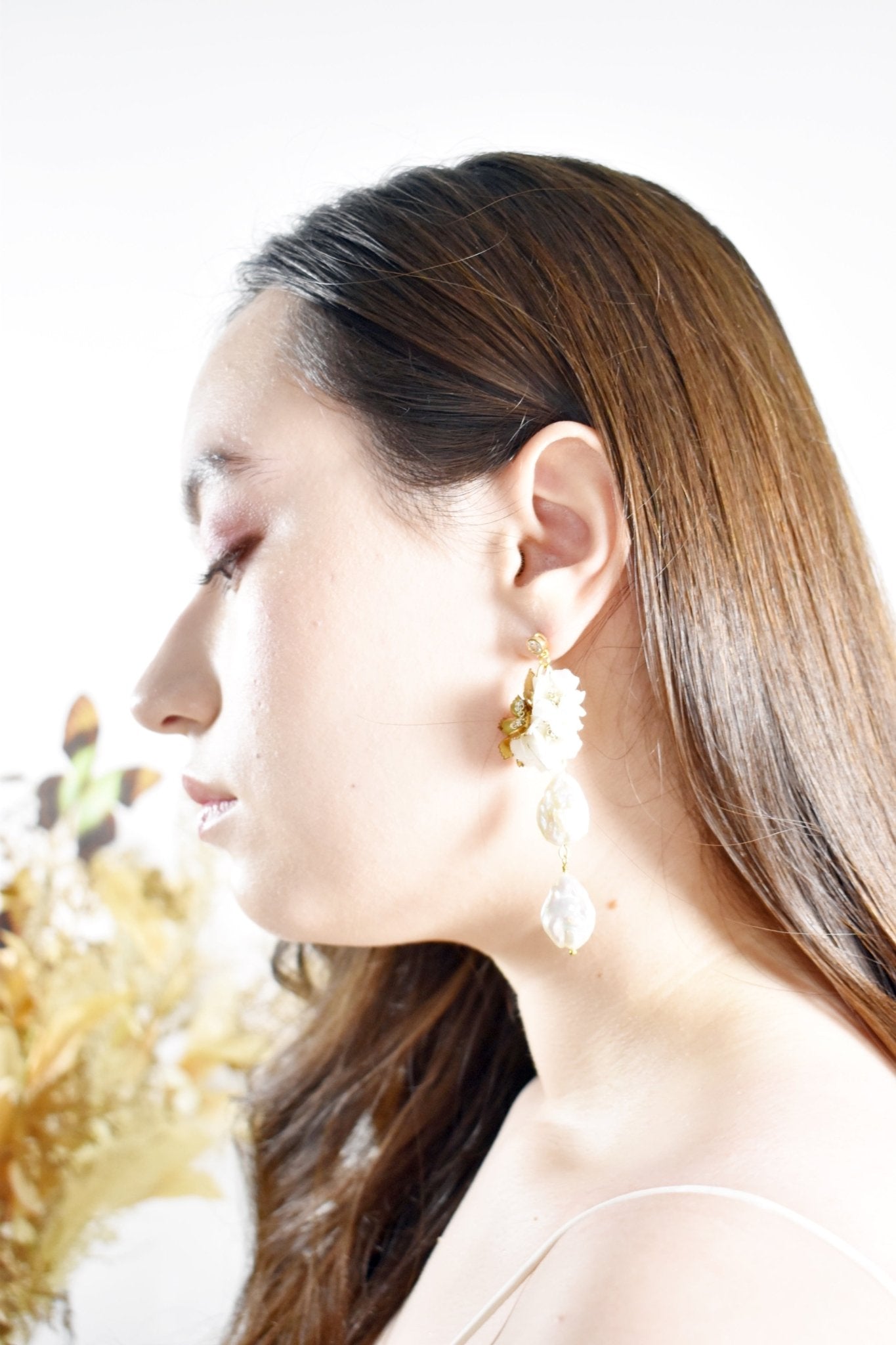 Close-up of a woman wearing gold earrings with a blurred background