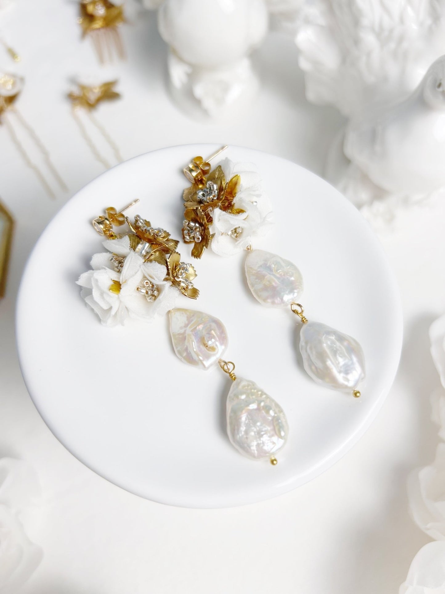 Pair of earrings on a white dish with a white background