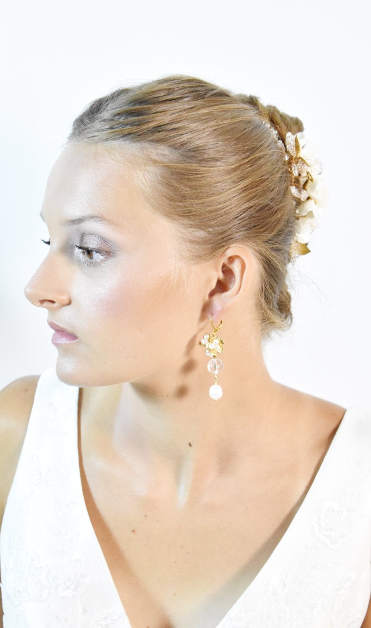 Woman wearing gold earrings on a white background