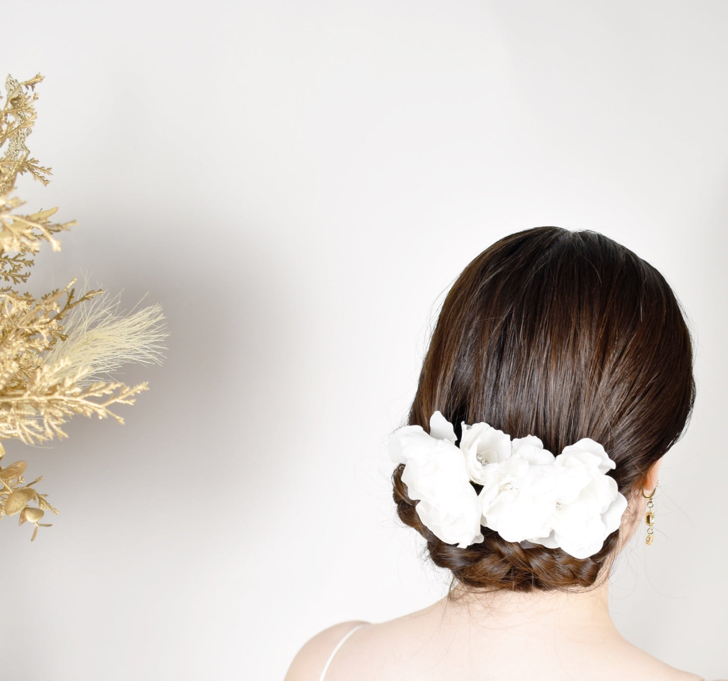 Woman with a floral hair accessory against a white background