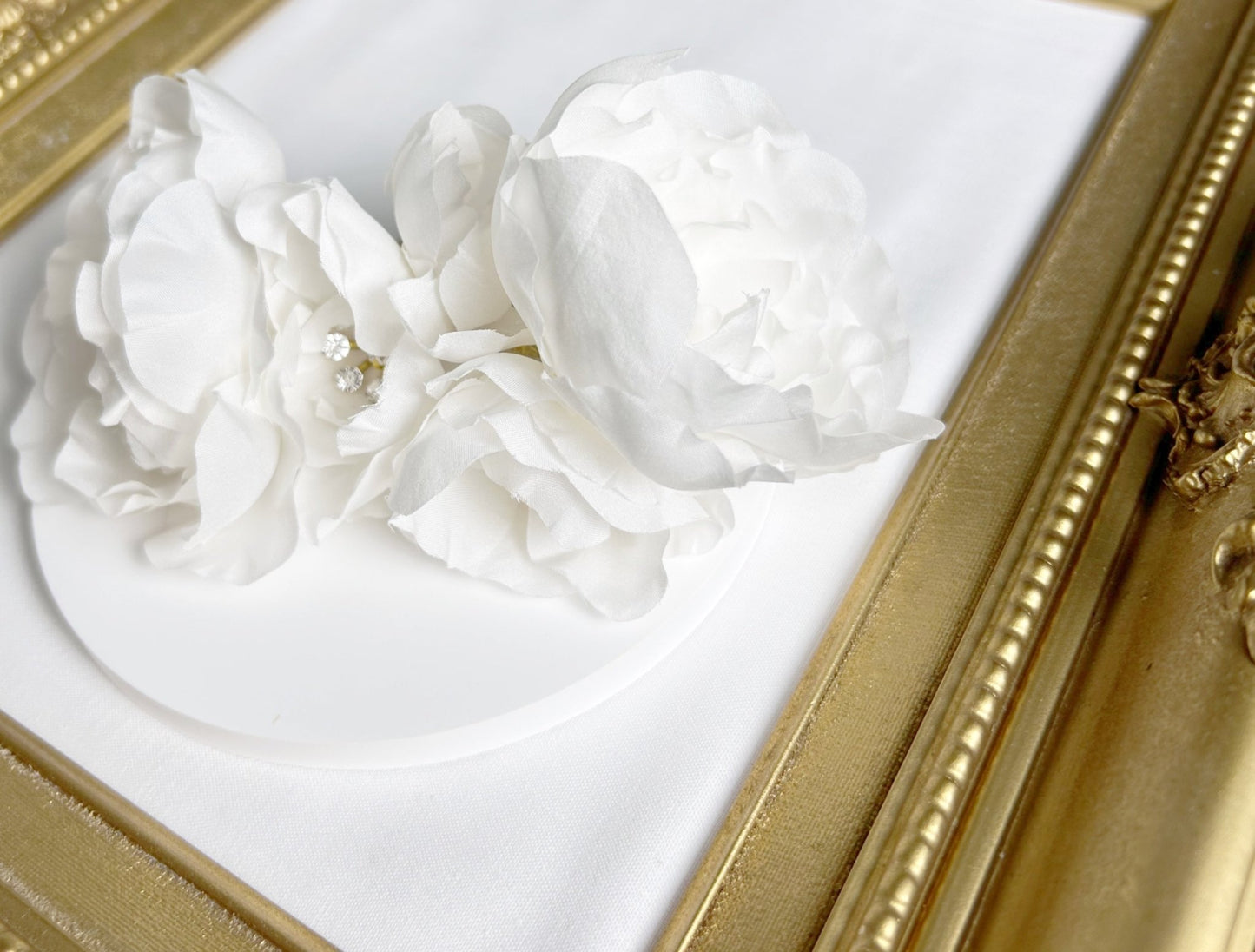 Decorative white floral arrangement in a gold frame