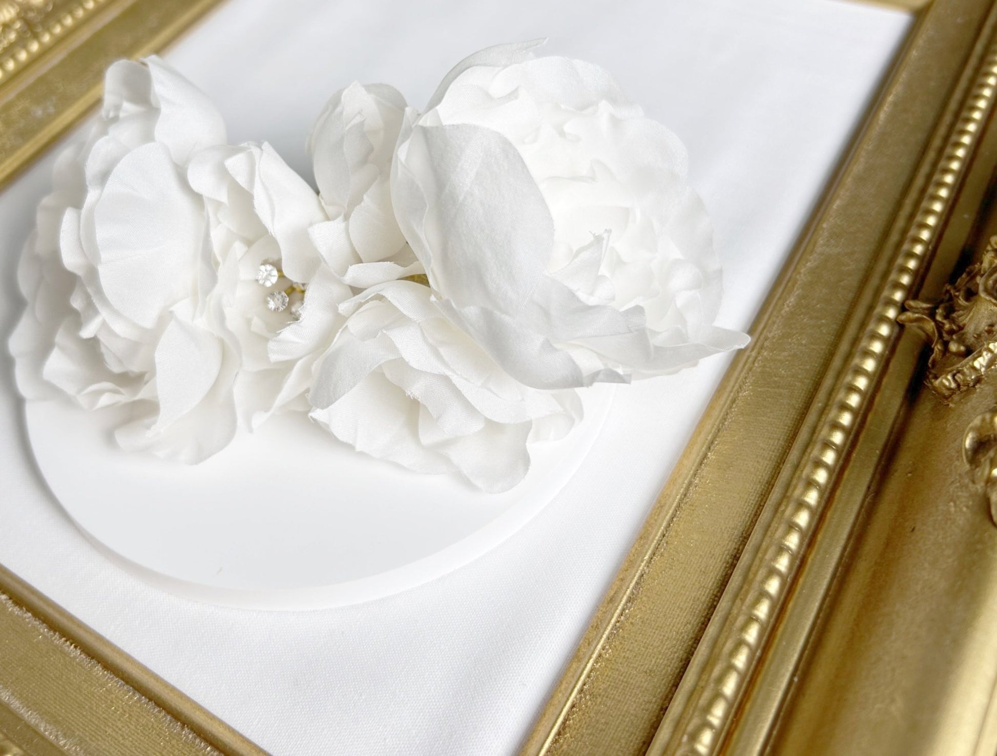 Decorative white floral arrangement in a gold frame