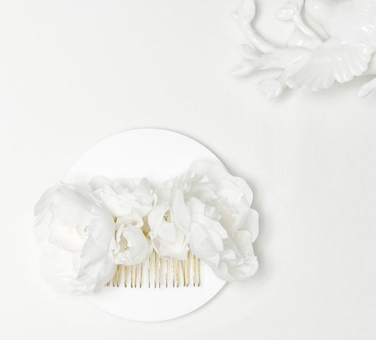 White floral hair comb on a white background