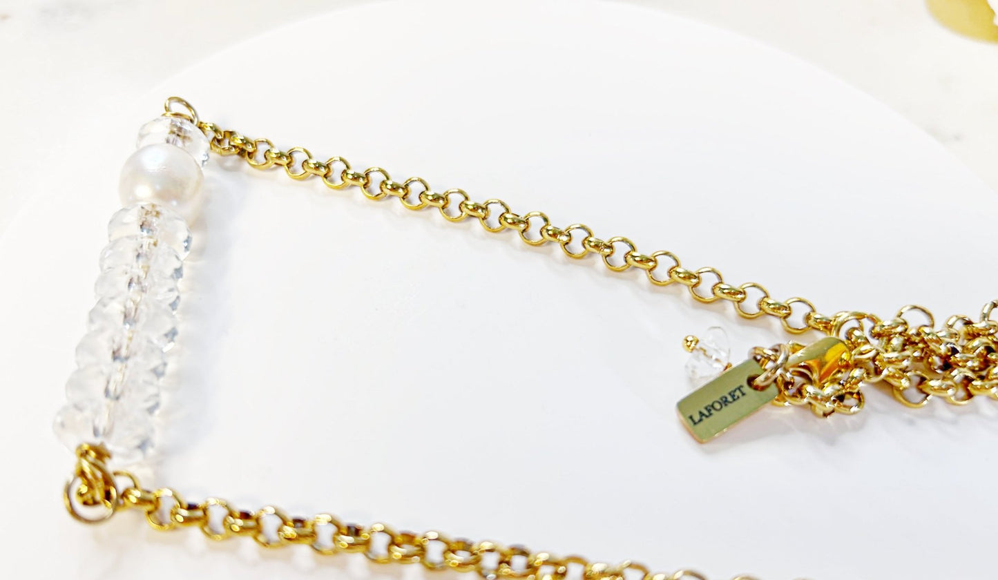 Gold chain necklace with pearls on a white background