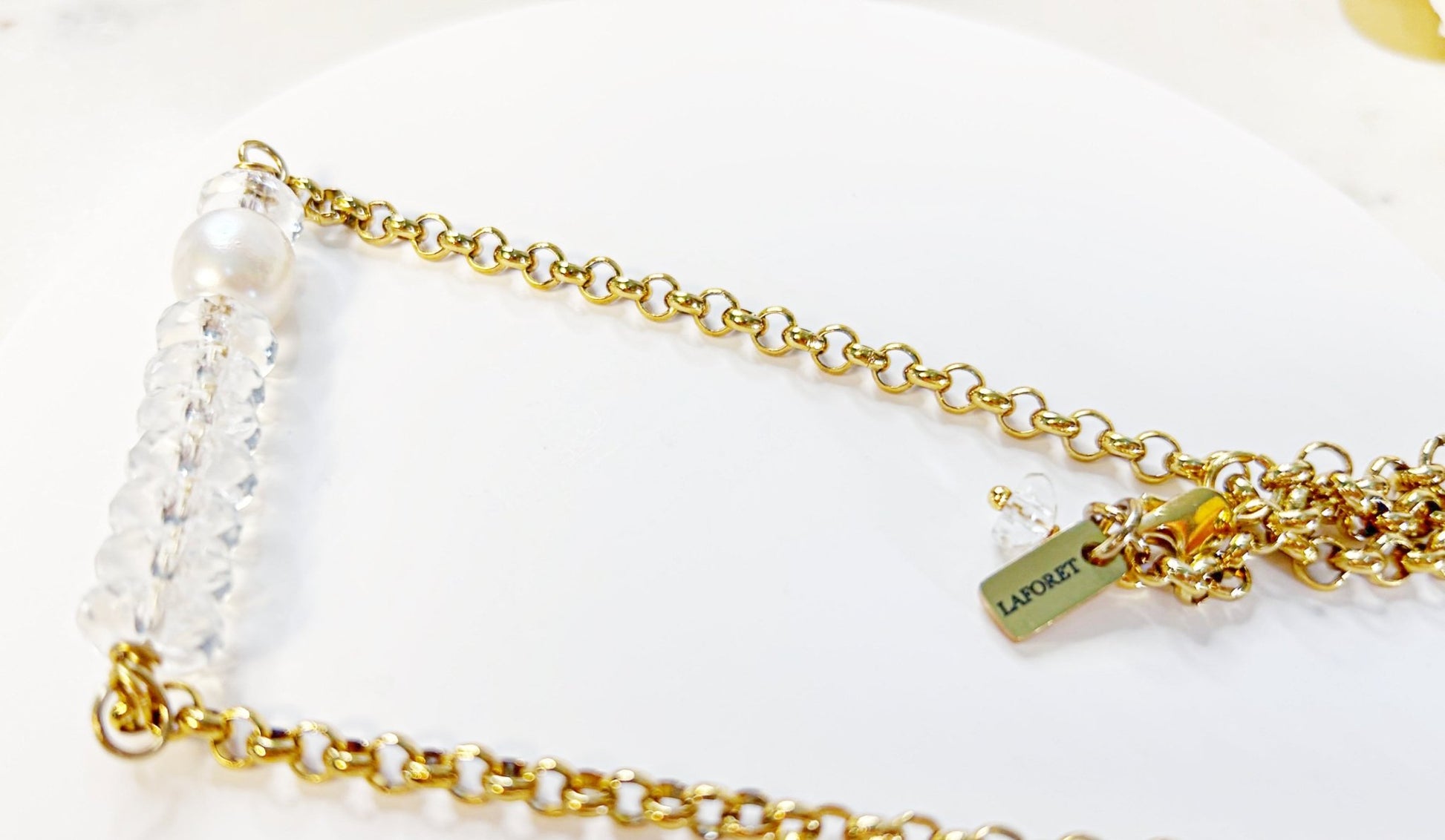 Gold chain necklace with pearls on a white background
