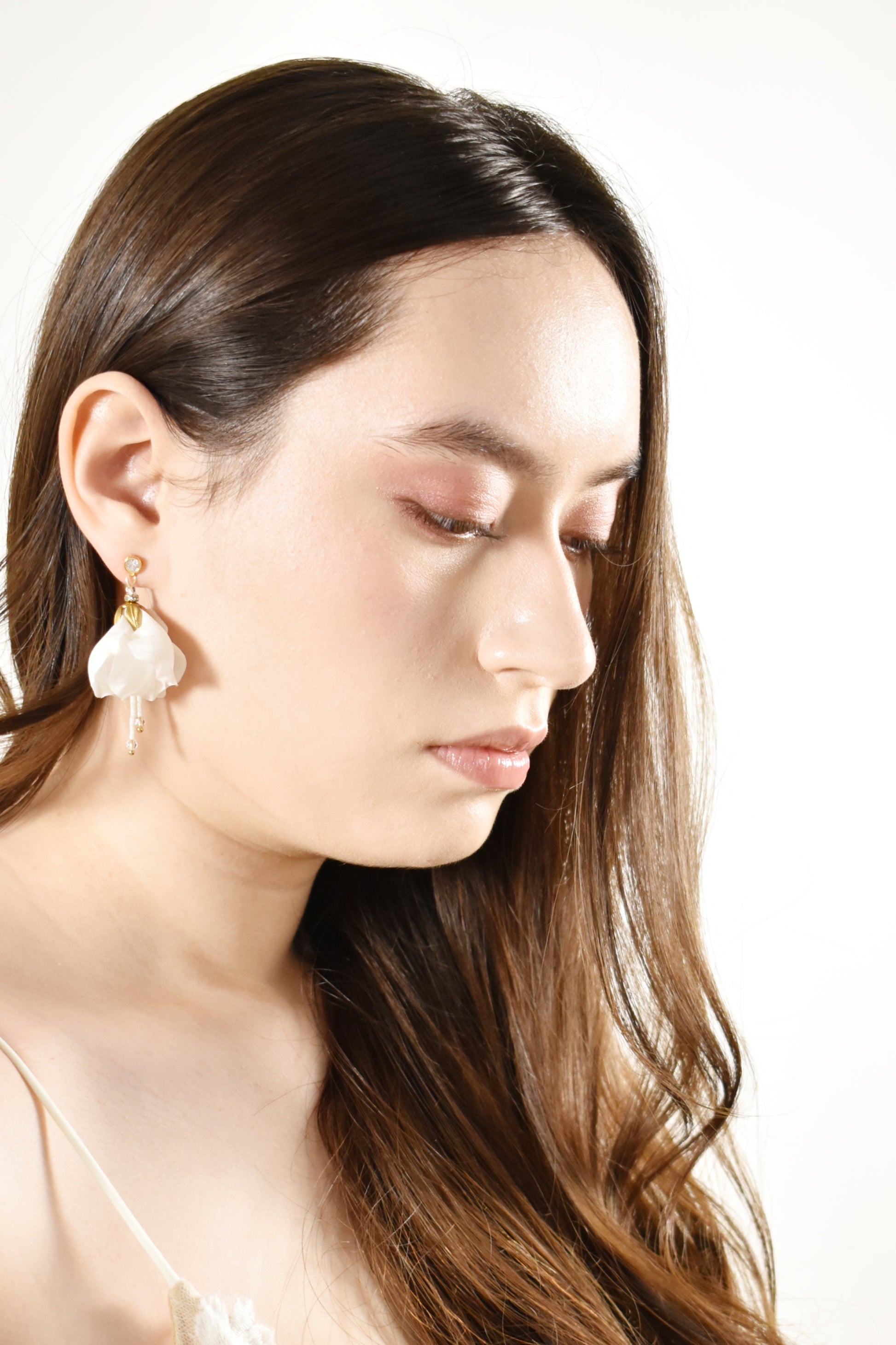 Woman wearing pearl earrings against a white background