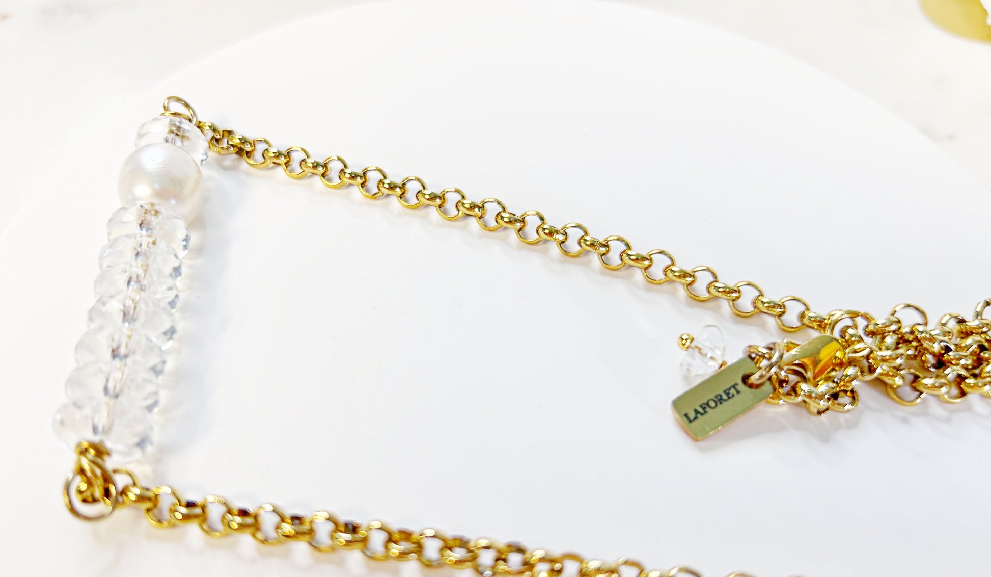 Gold chain necklace with pearls on a white background